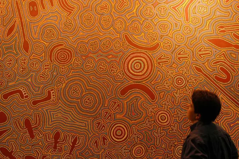 Patron viewing an Aboriginal dot painting