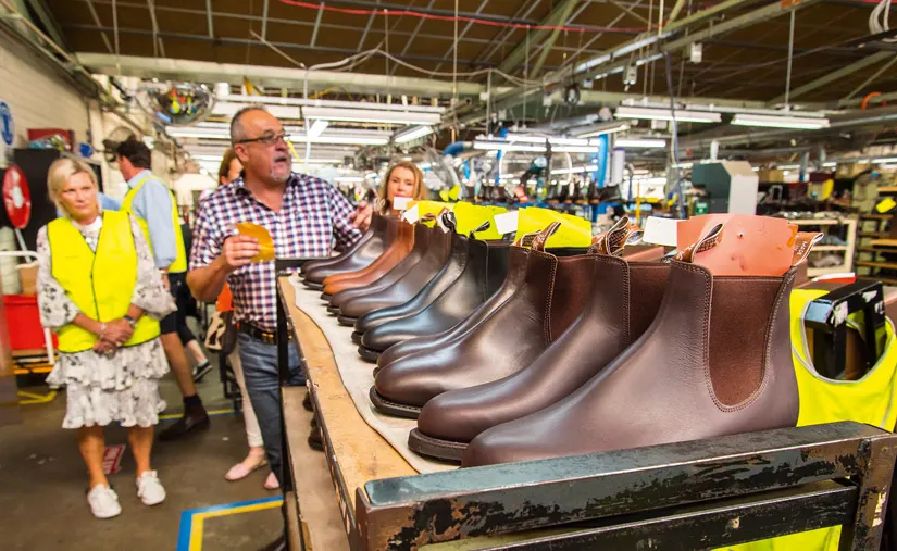 R.M.Williams employee showing guests around the workshop