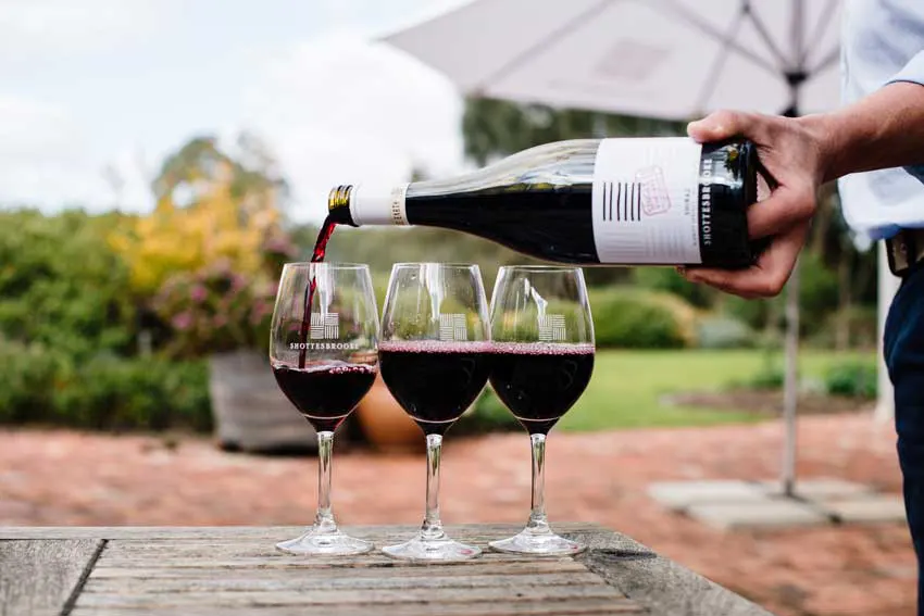 Three glasses of red wine being poured in the Shottesbrooke beer garden