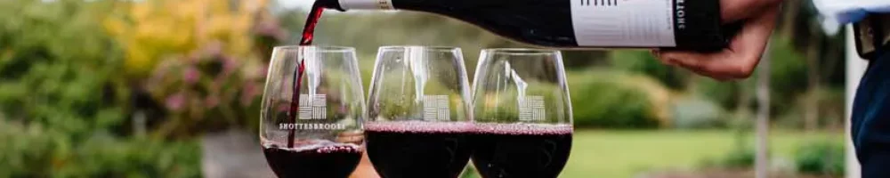 Three glasses of red wine being poured in the Shottesbrooke beer garden